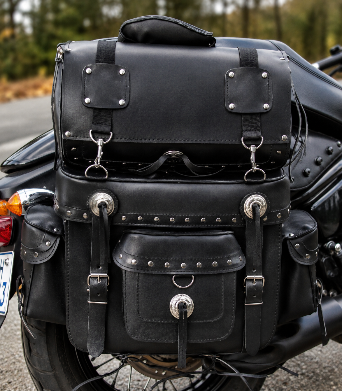 Black leather motorcycle saddlebags with metal clasps on a motorcycle.
