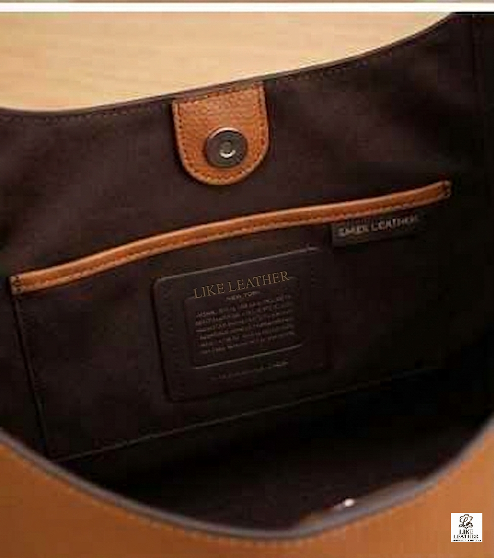 Close up of internal leather creed patch embossed with LIKE LEATHER brand name inside tan handbag.