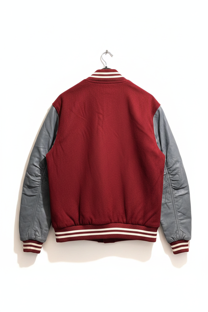 A classic varsity-style jacket shown from the back, featuring a deep red body and contrasting gray sleeves, with striped ribbed collar, cuffs, and hem.