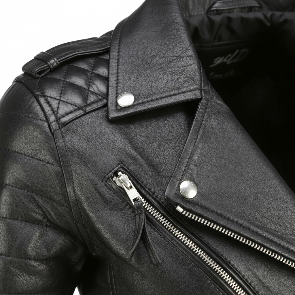 Close-up of a black leather jacket with quilted shoulder design and zipper detail.